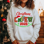 White hoodie with Christmas Crew 2025 design, decorated Christmas tree in background