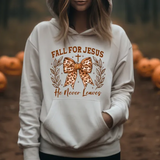 White hoodie with Fall for Jesus He Never Leaves text and leopard print bow design, surrounded by carved pumpkins