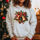 White hoodie with christmas bells, pinecones, and red berries print, christmas tree in background