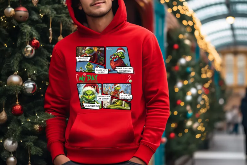 Red hoodie with comic-style grinch christmas printed panels against blurred christmas tree background