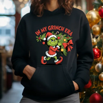 Black hoodie with In My Grinch Era Christmas design featuring cartoon Grinch in Santa outfit