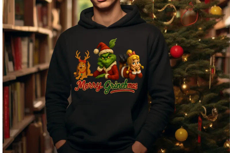 Black hoodie with Merry Grinchmas design featuring Grinch, Max, and Cindy Lou Who characters near Christmas tree