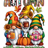 Three whimsical gnomes with long white beards sit together, wearing colorful autumn-themed hats adorned with sunflowers. They hold different beverages and are positioned near a pumpkin. The word "AUTUMN" is stylized above them, and "with my gnomies" appears below.