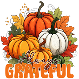 A cluster of pumpkins in orange, red, and white hues, surrounded by autumn leaves. Text reads: "Always GRATEFUL" in large orange letters.