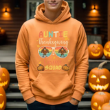 Orange hoodie with Auntie Thanksgiving Squad design featuring turkey sunglasses, surrounded by carved pumpkins