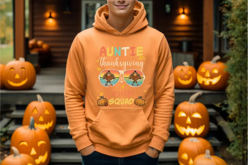 Orange hoodie with Auntie Thanksgiving Squad design featuring turkey sunglasses, surrounded by carved pumpkins