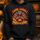 Black hoodie with cartoon turkey wearing headphones holding game controller surrounded by pumpkins