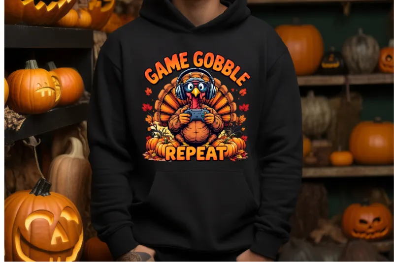 Black hoodie with cartoon turkey wearing headphones holding game controller surrounded by pumpkins