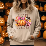 Beige hoodie with autumn-themed graphic featuring pumpkin, pink bow, and coffee cup with text Just a girl who loves fall