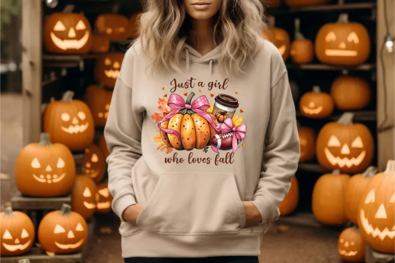 Beige hoodie with autumn-themed graphic featuring pumpkin, pink bow, and coffee cup with text Just a girl who loves fall