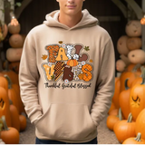 Cream hoodie with colorful fall-themed Fall Vibes design surrounded by orange pumpkins