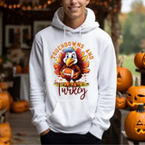 White hoodie with cartoon turkey holding football, surrounded by jack-o-lantern pumpkins, text reads Touchdowns and Turkey