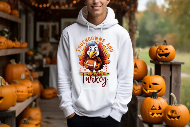 White hoodie with cartoon turkey holding football, surrounded by jack-o-lantern pumpkins, text reads Touchdowns and Turkey